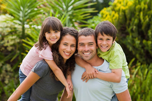 A smiling family protecting their two children from their previous marriage in their estate plan.